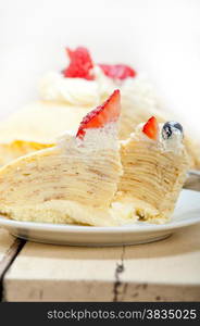 crepe pancake cake with whipped cream and strawberry on top