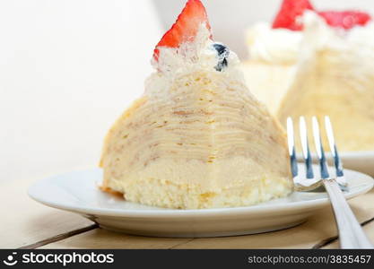 crepe pancake cake with whipped cream and strawberry on top