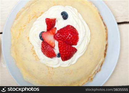crepe pancake cake with whipped cream and strawberry on top