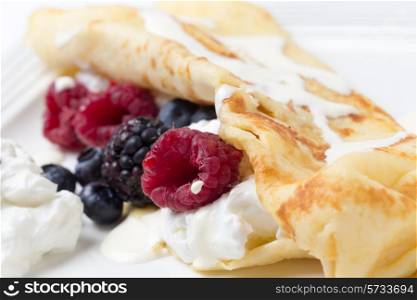 Crepe with yoghurt, raspberries, blackberries, blueberries, and a drizzling of cream