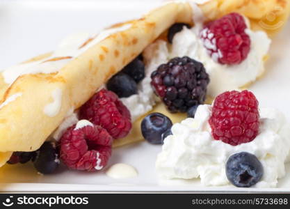 Crepe with yoghurt, raspberries, blackberries, blueberries, and a drizzling of cream