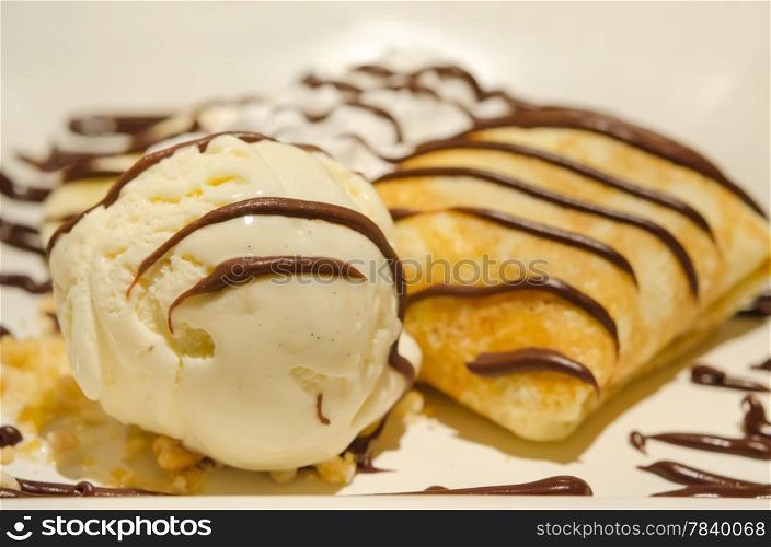 Crepes with banana , chocolate sauce served with whipping cream and vanilla ice cream
