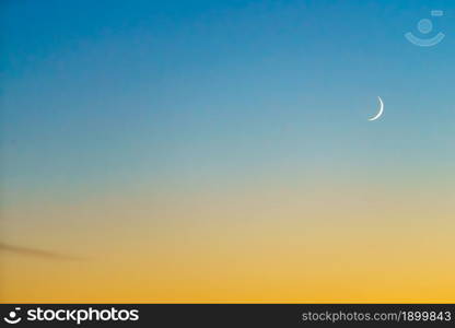 Crescent at the sunset sky. Sunset colors and new moon.