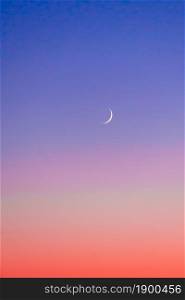 Crescent at the sunset sky. Sunset colors and new moon.