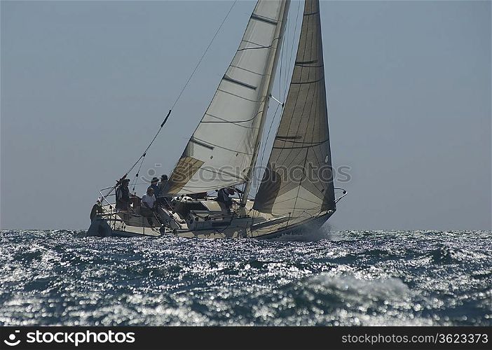 Crew members on board yacht competing in team sailing event California