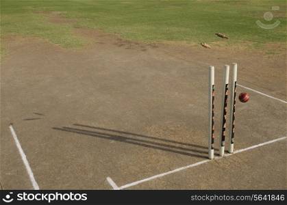 Cricket ball striking stumps
