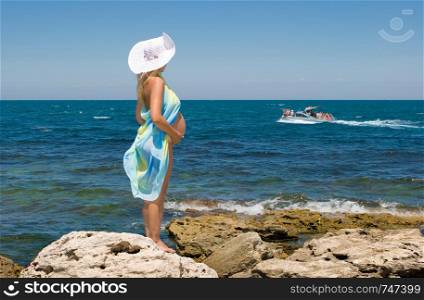 Crimea, the sea, rocks and a pregnant woman. Clear Skies.