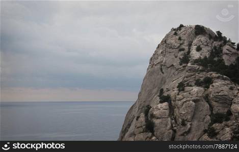 Crimean mountain peak against sea and cloudy sky
