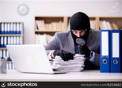 Criminal businessman wearing balaclava in office