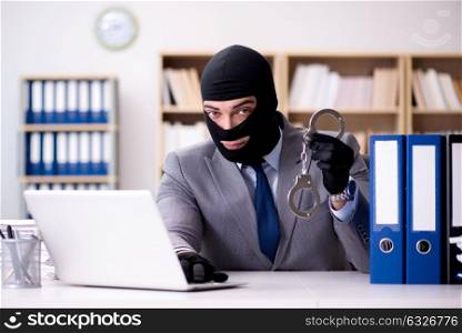 Criminal businessman wearing balaclava in office