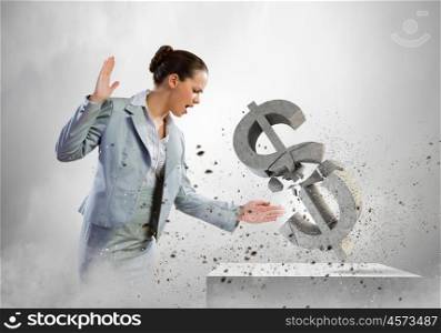 Crisis concept. Image of businesswoman breaking stone dollar symbol