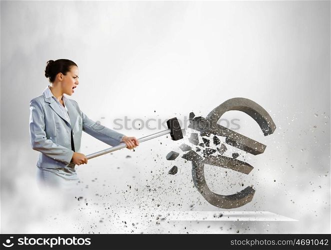 Crisis concept. Image of businesswoman crashing stone euro symbol