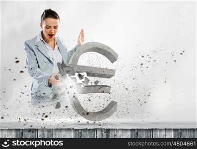 Crisis concept. Image of businesswoman crashing stone euro symbol