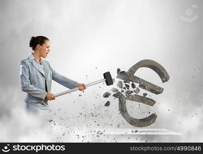 Crisis concept. Image of businesswoman crashing stone euro symbol