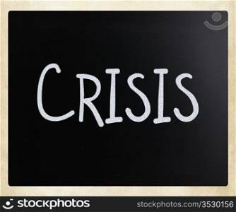 ""Crisis" handwritten with white chalk on a blackboard."