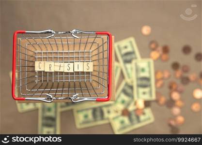 Crisis written with wooden cubes in iron shopping basket with Money coins and bills on the background, Business and Financial concept space for text. Crisis written with wooden cubes in iron shopping basket with Money coins and bills on the background, Business and Financial concept