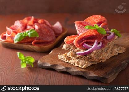 crisp bread with salami and red onion