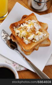 Crisp, fresh toast ricotta, honey and nuts for breakfast with orange juice
