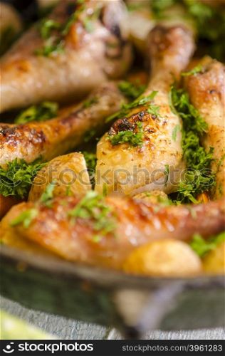 Crisp-tender chicken baked with roasted carrots and potatoes, shallow focus