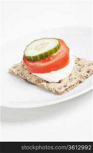 Crispbread with tomato and cucumber slice and cheese