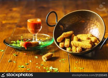 crispy chicken fingers copper utensil with sauce wooden table