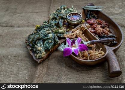 Crispy Flowers, Crispy Herbs and Crispy Vegetables served with Sweet sauce in a Wooden tray, Oblique view from the top, copy space.