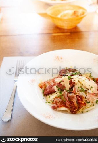 Crispy fried bacon with potato hash brown and cheese in white plate, Swiss European food.
