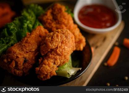 Crispy fried chicken on a cutting board with tomato sauce and carrot, Selective focus.