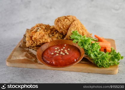 Crispy fried chicken on a cutting board with tomato sauce, Selective focus.