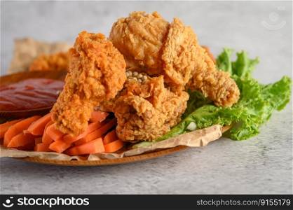 Crispy fried chicken on a plate with tomato sauce and carrot, Selective focus.