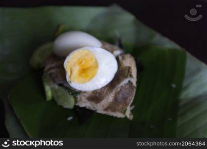 Crispy Gourami Fish and herb fried rice with boil egg on banana leaf