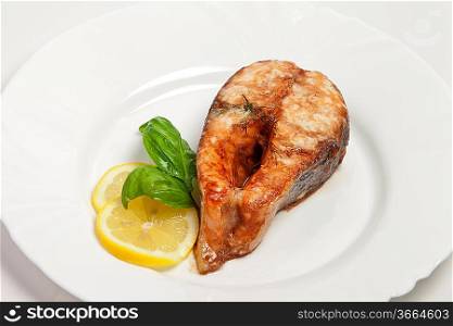 Crispy grilled salmon steak with lemon and basil