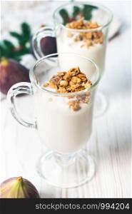 Crispy muesli in a glass with fresh yogurt and fresh figs, morning Breakfast, light snacks. Breakfast cereals isolated on white background, selective focus, top view.. Crispy muesli in a glass with fresh yogurt and fresh figs, morning Breakfast, light snacks. Breakfast cereals isolated on white background, selective focus, top view