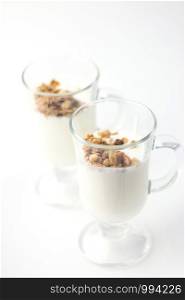 Crispy muesli in a glass with fresh yogurt, morning Breakfast, light snacks. Breakfast cereals isolated on white background, selective focus. Crispy muesli in a glass with fresh yogurt, morning Breakfast, light snacks. Breakfast cereals isolated on white background, selective focus.