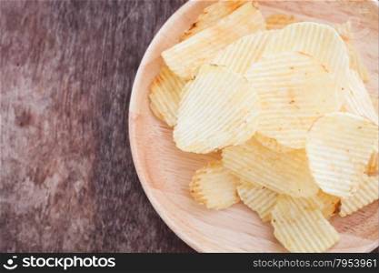 Crispy potato chips on wooden background, stock photo