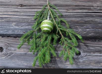 Cristmas tree twig and decoration against the shabby wooden wall background