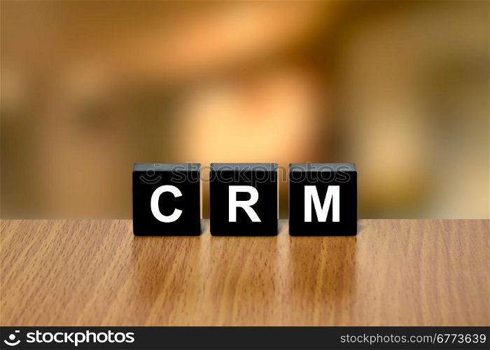 CRM or Customer relationship management on black block with blurred background
