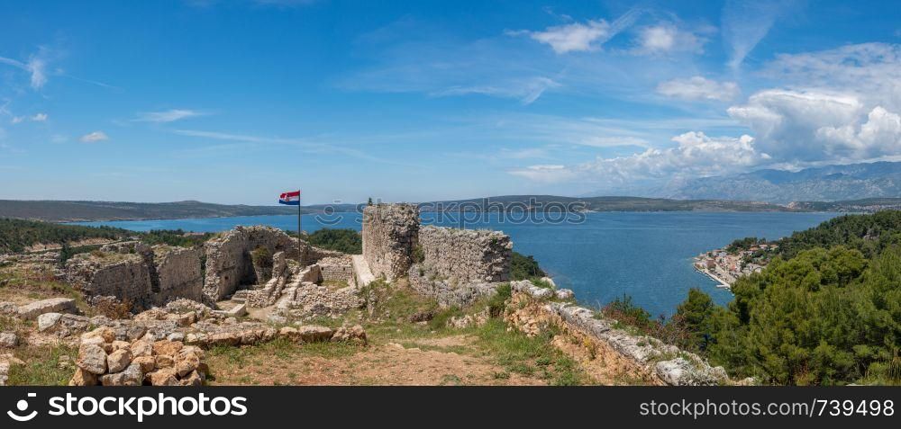 Croatian flag flies above ruins of old Venetian fort above the coastal town of Novigrad in Croatia. Flag on top of fortress above the Croatian town of Novigrad in Istria County