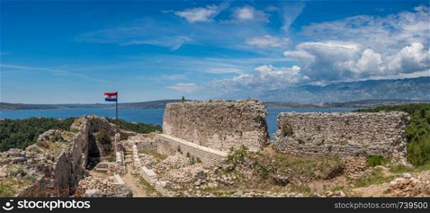 Croatian flag flies above ruins of old Venetian fort above the coastal town of Novigrad in Croatia. Flag on top of fortress above the Croatian town of Novigrad in Istria County