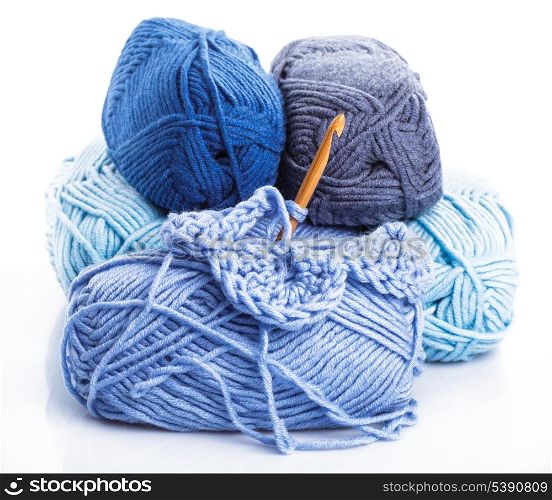 Crocheting with blue a balls of yarn on white