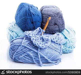 Crocheting with blue a balls of yarn on white