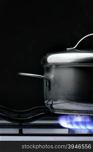Crock on the gas stove over black background