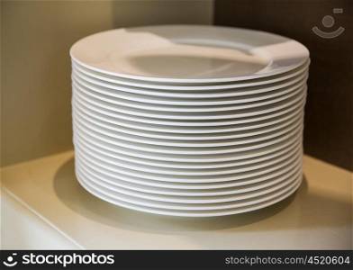 crockery and dishes concept - close up of plates on cupboard shelf. close up of plates on cupboard shelf