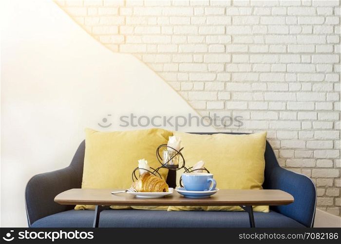 Croissant and coffee for breakfast in white living room
