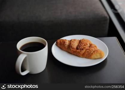 Croissant and coffee in coffee shop