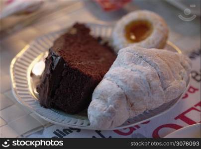 Croissant, cake and biscuit on a plate