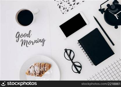 croissant coffee cup with good morning message paper office stationaries white desk