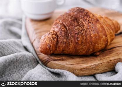 croissant with chocolate powder on a wooden board