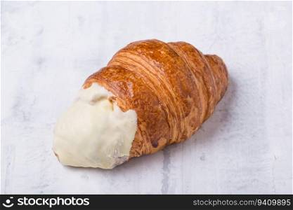 croissant with cream filling on a light background. french croissant on light background
