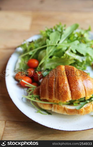 croissant with egg and bacon on wood background